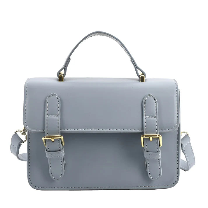 Model holding Ishna Bag – minimalist PU leather clutch with flap pocket and hasp closure in compact structured silhouette by Vespera The Label