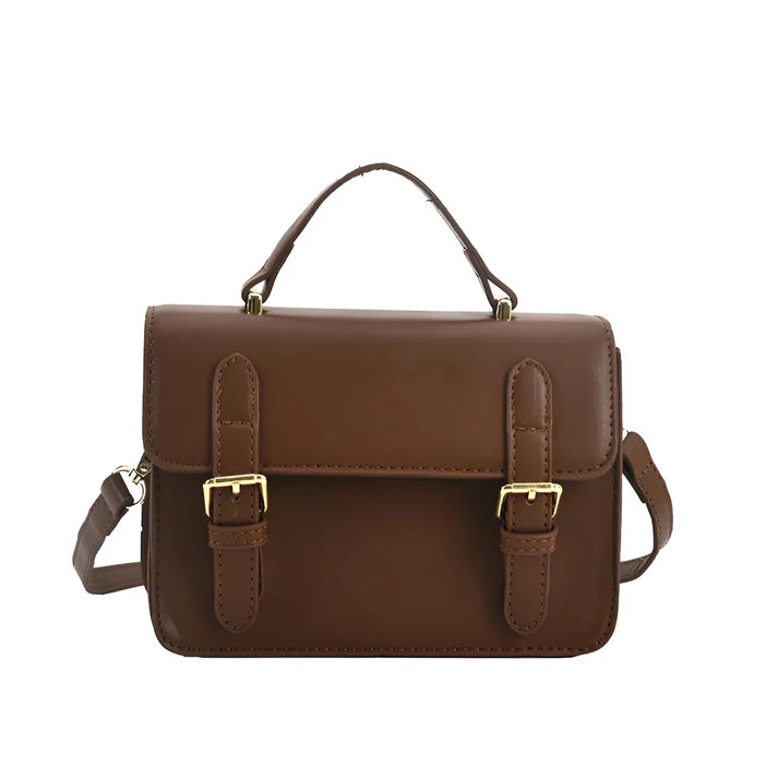 Model holding Ishna Bag – minimalist PU leather clutch with flap pocket and hasp closure in compact structured silhouette by Vespera The Label