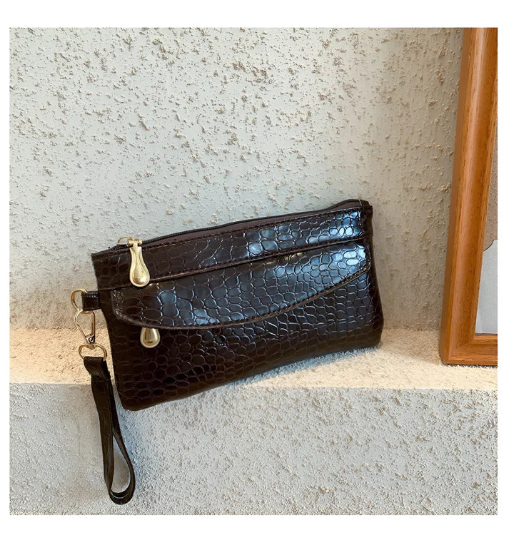 Model holding Bodhi Bag – minimalist PU wallet clutch with zipper closure and sequined sparkle finish by Vespera The Label