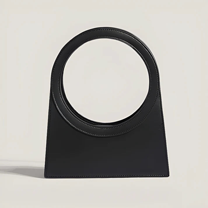 Model holding Miriah Bag – compact PU leather handbag with ring handle, high-end finish, and minimalist motorcycle-inspired design by Vespera The Label