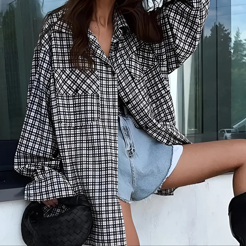 This image features the Minas Jacket, a stylish outerwear piece perfect for adding a trendy touch to any outfit. The jacket is designed with a bold, black and white plaid pattern, creating a classic yet modern look.
