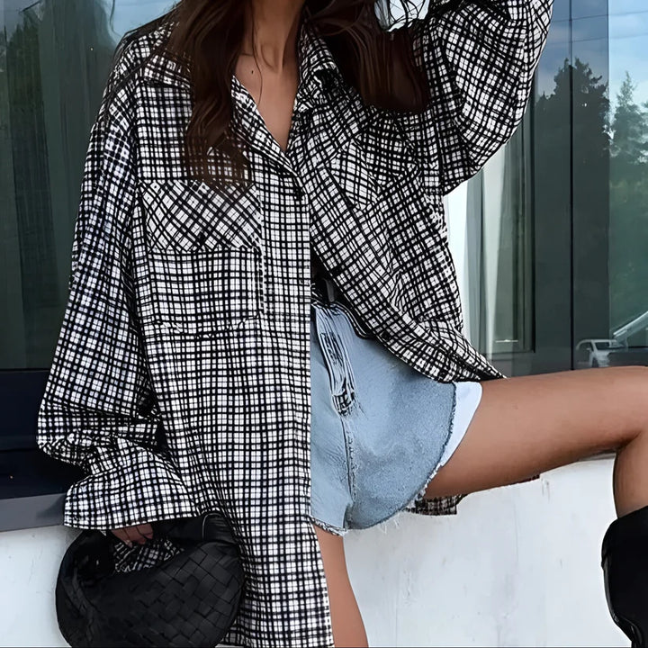 This image features the Minas Jacket, a stylish outerwear piece perfect for adding a trendy touch to any outfit. The jacket is designed with a bold, black and white plaid pattern, creating a classic yet modern look.