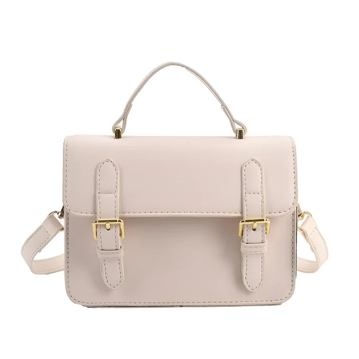 Model holding Ishna Bag – minimalist PU leather clutch with flap pocket and hasp closure in compact structured silhouette by Vespera The Label